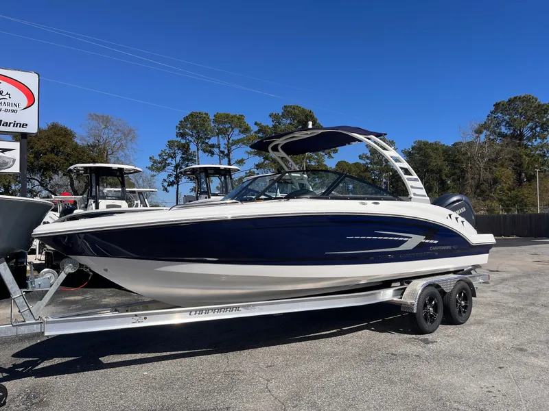 Slide: The Image of 2025 Chaparral 21 SSi OB boat on trailer, parked outdoors under clear blue sky. - 1