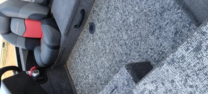 Slide: The Image of 2025 Tracker Pro Team 190 boat interior with gray carpet and black-red seating. - 10