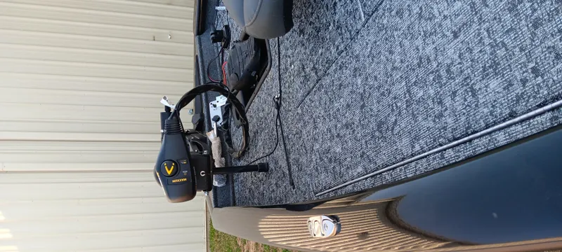 Slide: The Image of 2025 Tracker Pro Team 190 boat interior with motor and carpeted deck. - 16