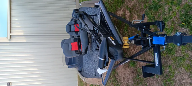 Slide: The Image of 2025 Tracker Pro Team 190 boat with seats and motor, parked on grass. - 18