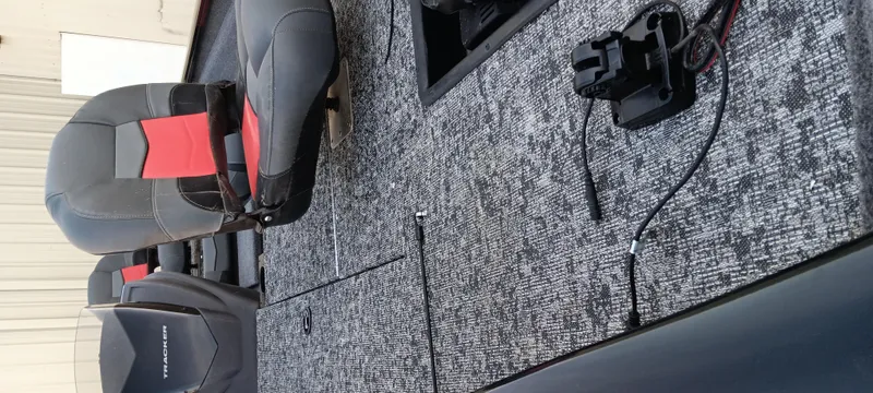 Slide: The Image of 2025 Tracker Pro Team 190 boat interior with gray and red seating, carpeted flooring, and equipment. - 20