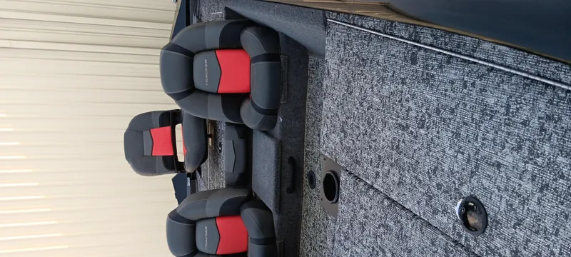 Slide: The Image of 2025 Tracker Pro Team 190 boat interior with gray carpet and black-red seats. - 7