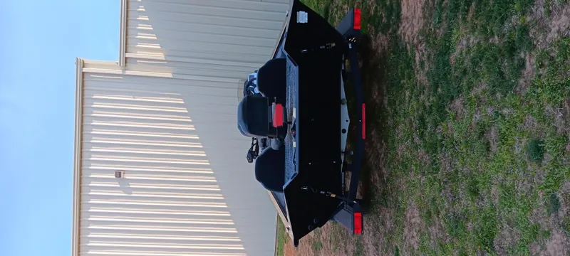 Slide: The Image of 2025 Tracker Pro Team 190 boat on trailer, parked beside a white building. - 8