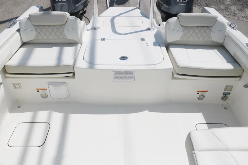 Slide: The Image of 2025 World Cat 230 DC boat interior with cushioned seating and dual outboard motors. - 12