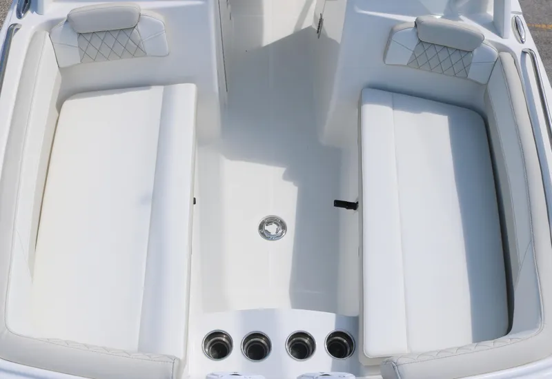 Slide: The Image of 2025 World Cat 230 DC boat interior with white cushioned seating and cup holders. - 6