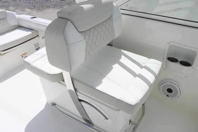 Slide: The Image of 2025 World Cat 230 DC boat interior with white cushioned seating and cup holders. - 7