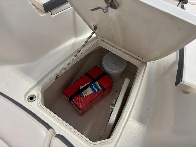 Slide: The Image of Open storage compartment on 2017 Robalo R302 Center Console boat with safety equipment. - 17