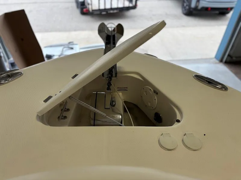 Slide: The Image of 2017 Robalo R302 Center Console anchor compartment with open hatch in a garage setting. - 18