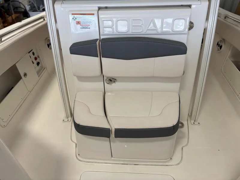 Slide: The Image of 2017 Robalo R302 Center Console boat seating area with cushioned seats and storage compartments. - 21