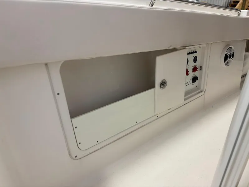 Slide: The Image of 2017 Robalo R302 Center Console boat interior with control panel and storage compartment. - 23