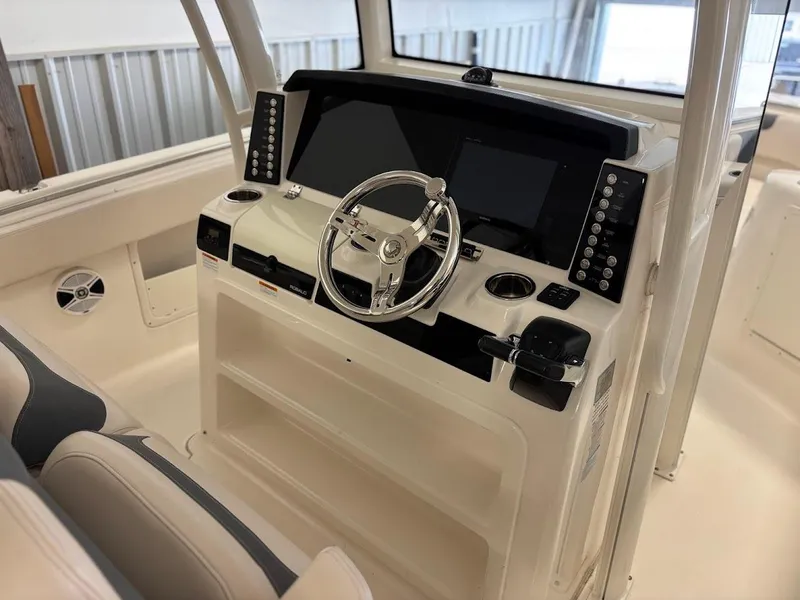 Slide: The Image of 2017 Robalo R302 Center Console boat dashboard with steering wheel and control panels. - 26