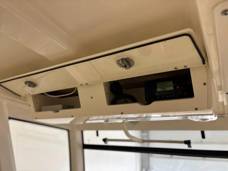Slide: The Image of 2017 Robalo R302 Center Console overhead storage with radio equipment. - 28