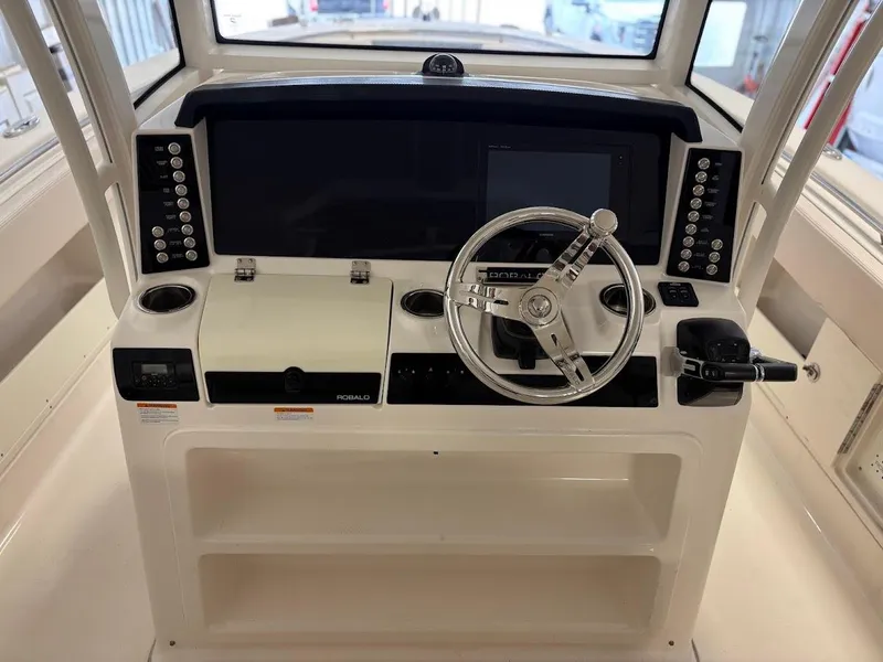 Slide: The Image of 2017 Robalo R302 Center Console boat dashboard with steering wheel and control panel. - 9