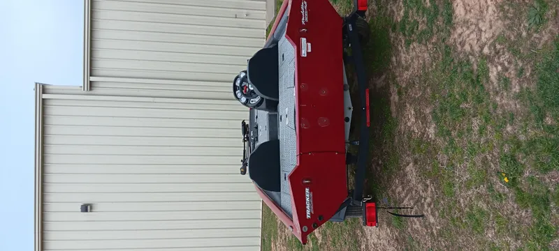 Slide: The Image of 2022 Tracker Pro Team 175 TXW boat, red, parked near a beige building. - 12