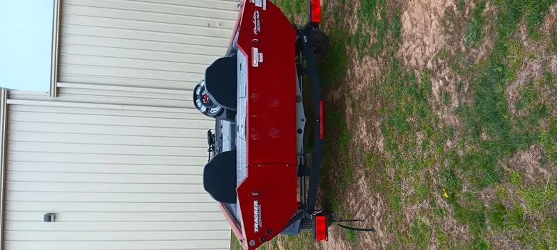 Slide: The Image of Red 2022 Tracker Pro Team 175 TXW boat parked on grass near a building. - 13