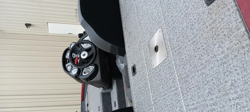 Slide: The Image of 2022 Tracker Pro Team 175 TXW boat interior with steering wheel and carpeted deck. - 15