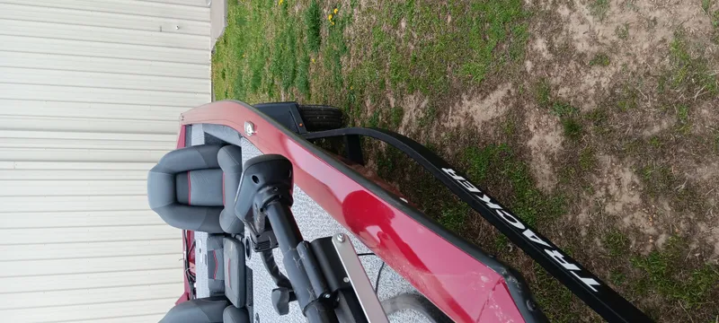 Slide: The Image of 2022 Tracker Pro Team 175 TXW boat, red, parked on grass near a building. - 6