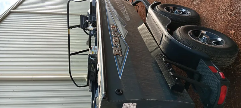 Slide: The Image of 2025 Ranger VX1788 WT boat on trailer, parked beside a metal building. - 4