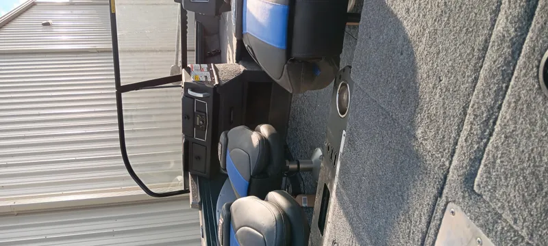 Slide: The Image of 2025 Ranger VX1788 WT boat interior with blue and black seating, gray carpet, and control panel. - 6