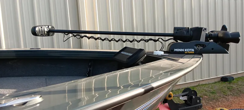 Slide: The Image of 2025 Ranger VX1788 WT boat with Minn Kota trolling motor, docked near a metal building. - 8