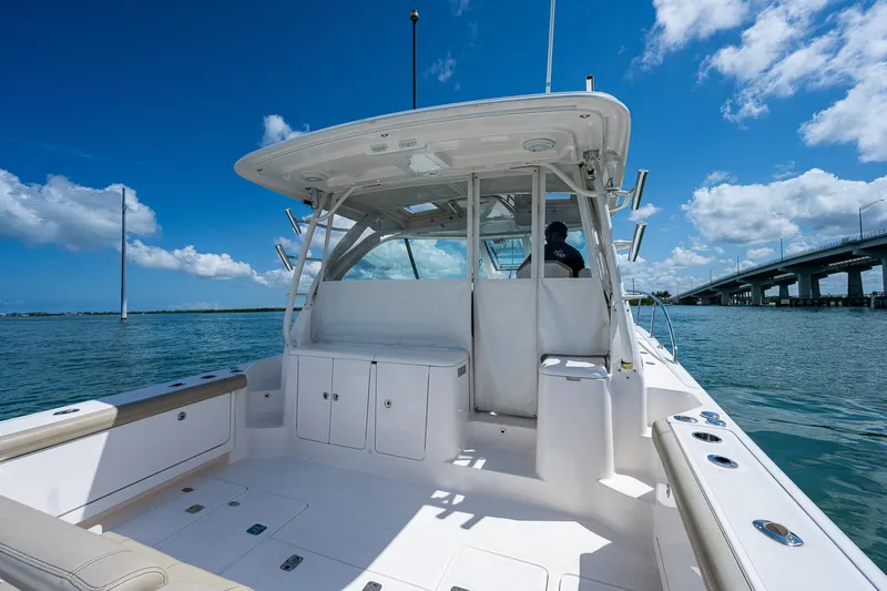 Slide: The Image of 2018 Pursuit OS 385 Offshore boat on water, clear sky, bridge in background. - 10
