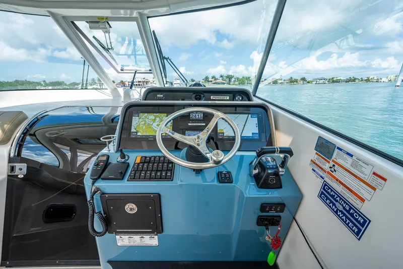 Slide: The Image of 2018 Pursuit OS 385 Offshore boat helm with navigation equipment and steering wheel. - 22
