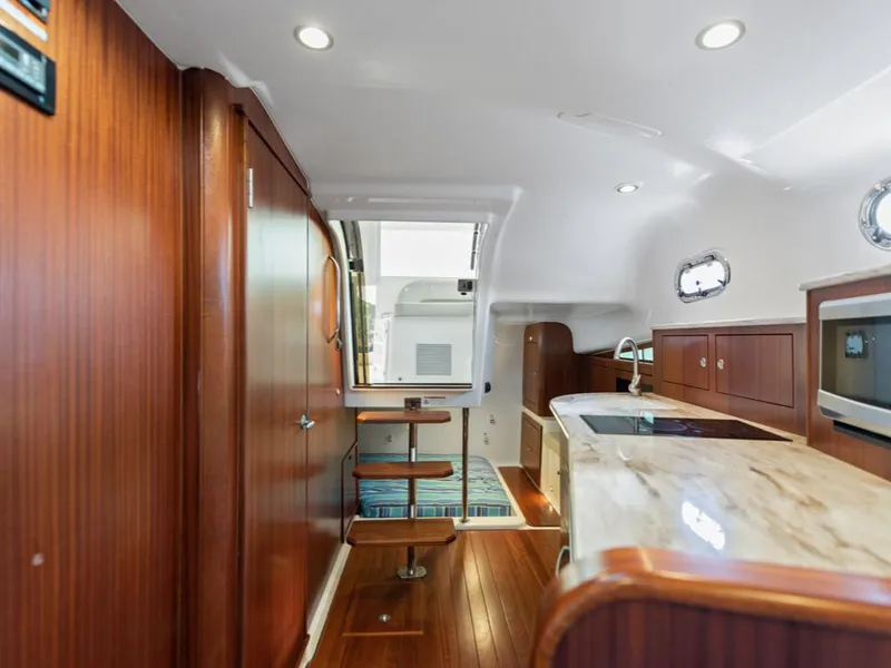Slide: The Image of 2018 Pursuit OS 385 Offshore yacht interior with wooden cabinetry and modern kitchen amenities. - 26