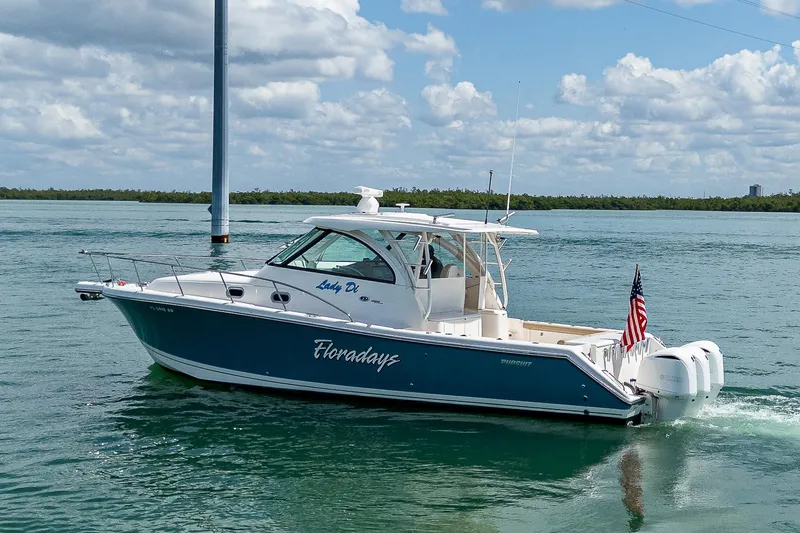 Slide: The Image of 2018 Pursuit OS 385 Offshore boat cruising on a sunny day with American flag. - 4