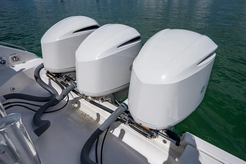 Slide: The Image of 2018 Pursuit OS 385 Offshore boat with triple outboard engines on calm water. - 41