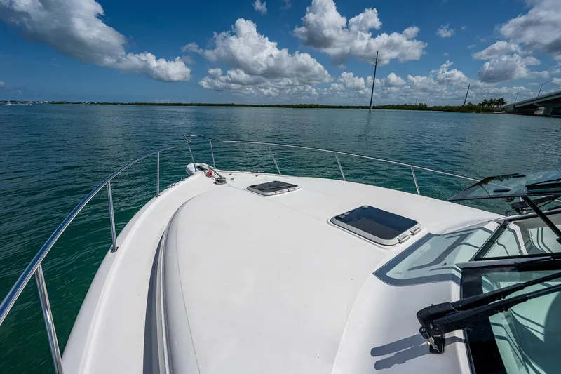 Slide: The Image of 2018 Pursuit OS 385 Offshore boat on calm water under a blue sky with clouds. - 8