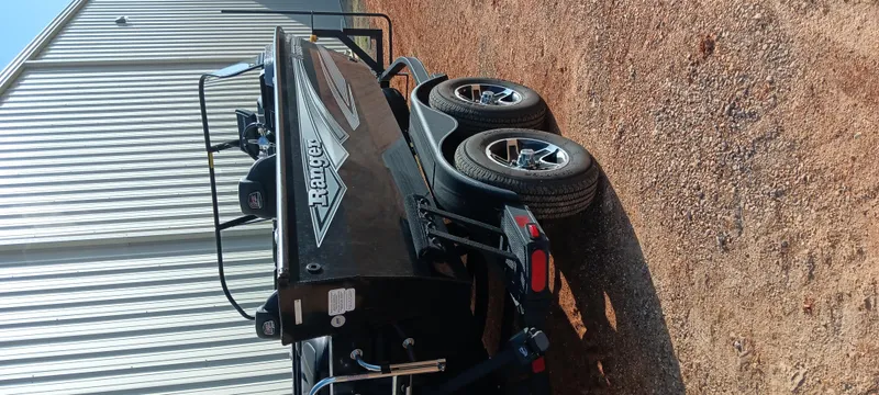 Slide: The Image of 2025 Ranger VX1888 WT boat on trailer, parked on gravel near metal building. - 20