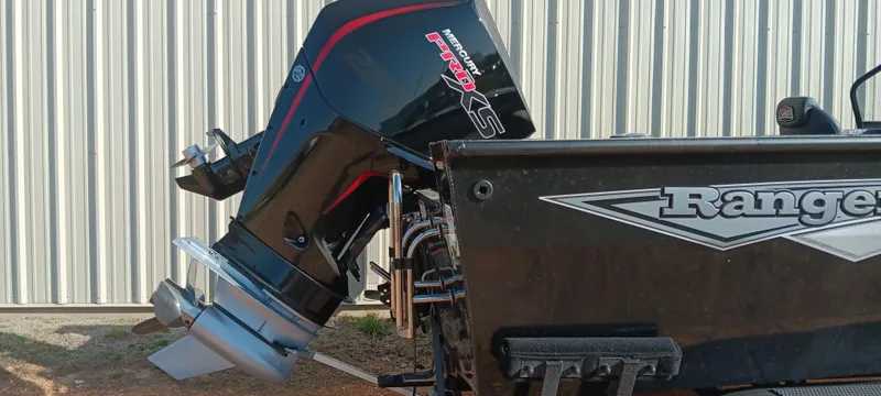 Slide: The Image of 2025 Ranger VX1888 WT boat with powerful outboard motor, parked near a corrugated metal wall. - 3