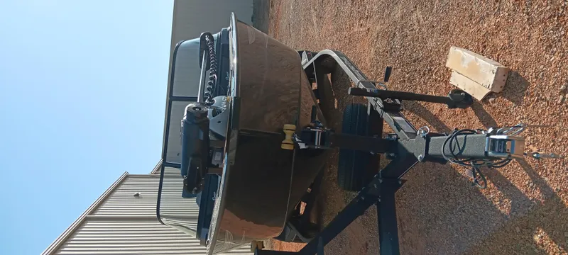 Slide: The Image of 2025 Ranger VX1888 WT boat on trailer, parked on gravel near a building. - 7