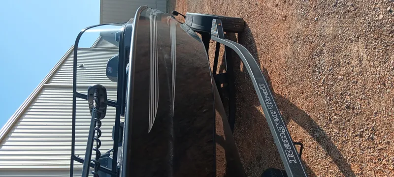 Slide: The Image of 2025 Ranger VX1888 WT boat on trailer, parked on gravel near a metal building. - 9