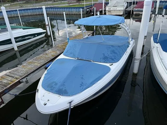 Slide: The Image of 2022 Chaparral 21 SSi boat docked with blue covers and canopy. - 3