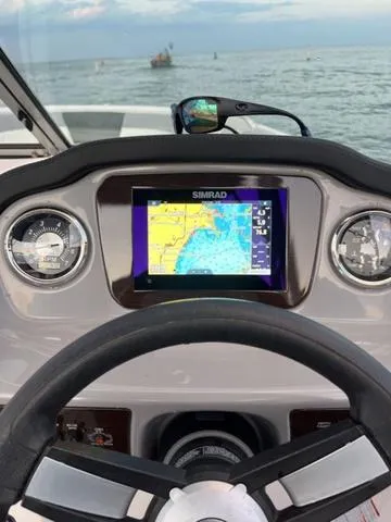 Slide: The Image of 2022 Chaparral 21 SSi boat dashboard with Simrad navigation system on open water. - 7