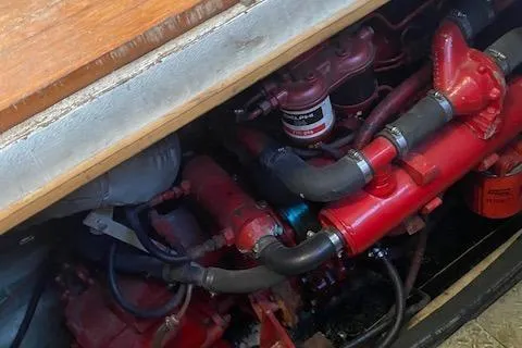 Slide: The Image of Engine compartment of a 1987 President 36 boat, featuring red mechanical components. - 7