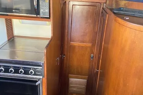 Slide: The Image of 1987 President 36 yacht kitchen with wooden cabinetry, stove, and microwave. - 8