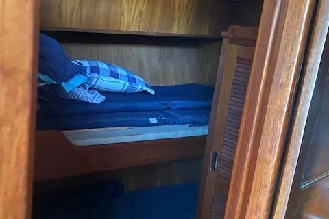 Slide: The Image of Cozy wooden cabin bunk bed with blue bedding, inside a 1987 President 36 model. - 9