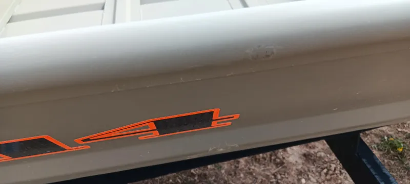 Slide: The Image of 2025 Tracker Grizzly 1436 Utility boat detail with orange decal on side. - 7