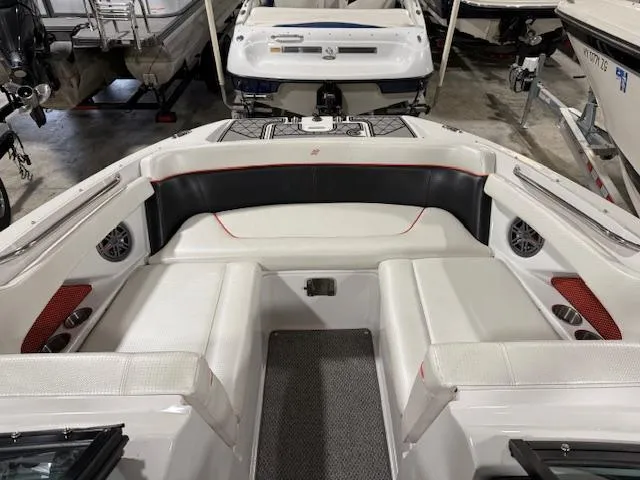 Slide: The Image of 2016 Four Winns TS242 boat interior with white seating and black accents in a showroom. - 5