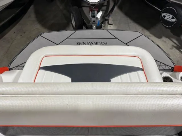 Slide: The Image of 2016 Four Winns TS242 boat interior with cushioned seating and logo. - 8