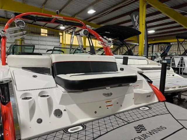 Slide: The Image of 2016 Four Winns TS242 boat with red accents in a showroom. - 9