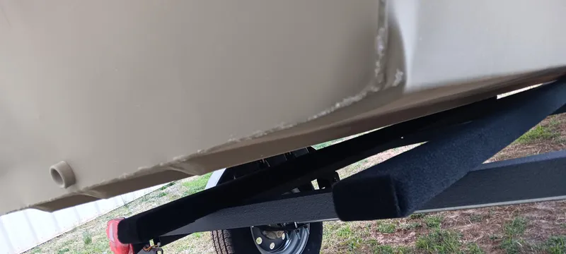 Slide: The Image of 2025 Tracker Grizzly 1436 Utility boat underside on trailer, showing hull and wheel detail. - 10