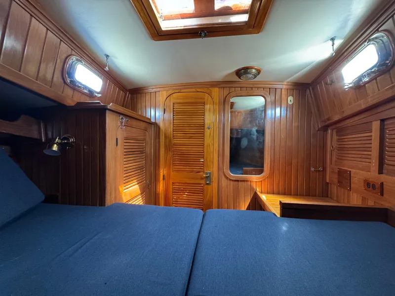 Slide: The Image of Cozy cabin interior of 1988 Cabo Rico 38XL sailboat with wooden paneling and blue bedding. - 12