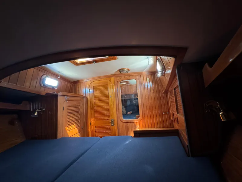 Slide: The Image of Interior cabin of 1988 Cabo Rico 38XL sailboat with wooden paneling and blue cushions. - 15