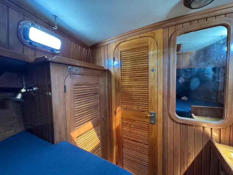 Slide: The Image of Interior of 1988 Cabo Rico 38XL sailboat with wooden paneling and blue upholstery. - 17