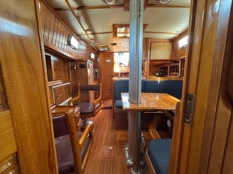 Slide: The Image of Interior of 1988 Cabo Rico 38XL sailboat with wooden furnishings and cozy seating area. - 21
