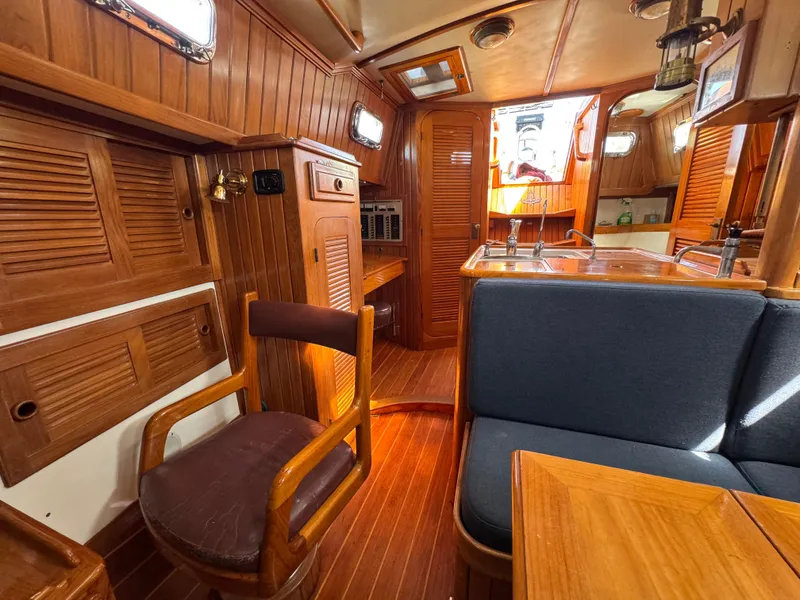 Slide: The Image of Interior of 1988 Cabo Rico 38XL sailboat with wooden furnishings and seating area. - 26
