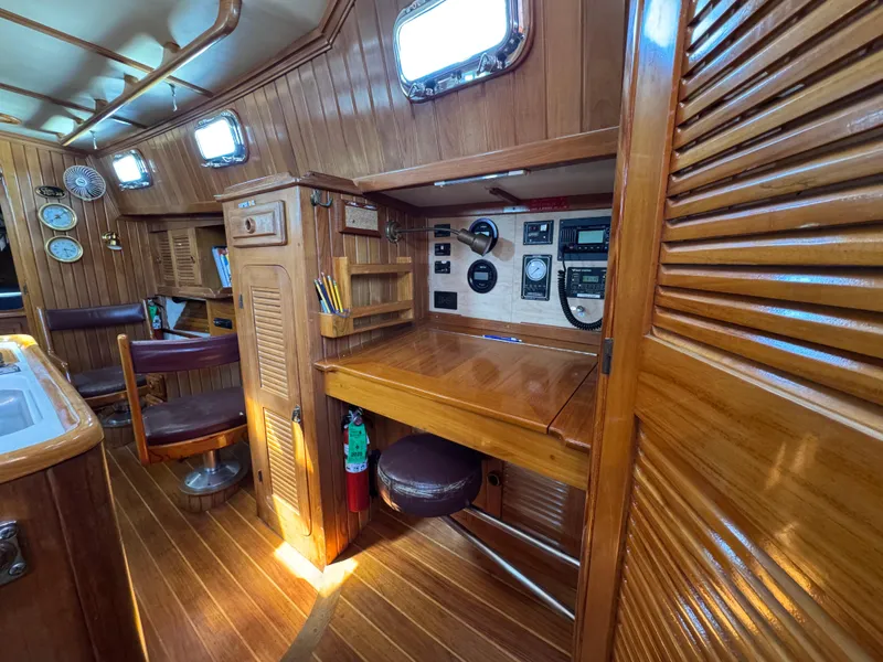 Slide: The Image of 1988 Cabo Rico 38XL yacht interior with wooden finish, navigation station, and seating area. - 29